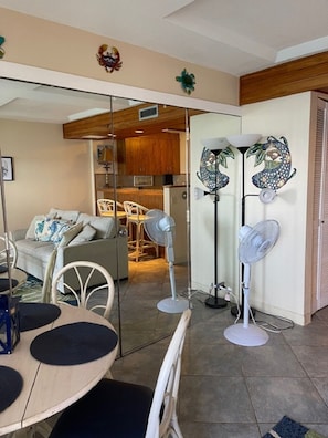 A modern living room with a dining area, a kitchen in the background, and decorative wall art. - Hawaiian Prinicess one bedroom
1990/NUC-2240 (Waianae)