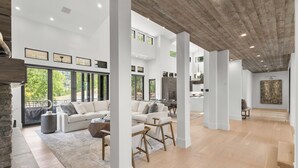 Un espacio habitable amplio con techos altos, ventanas grandes y un diseño moderno de concepto abierto.