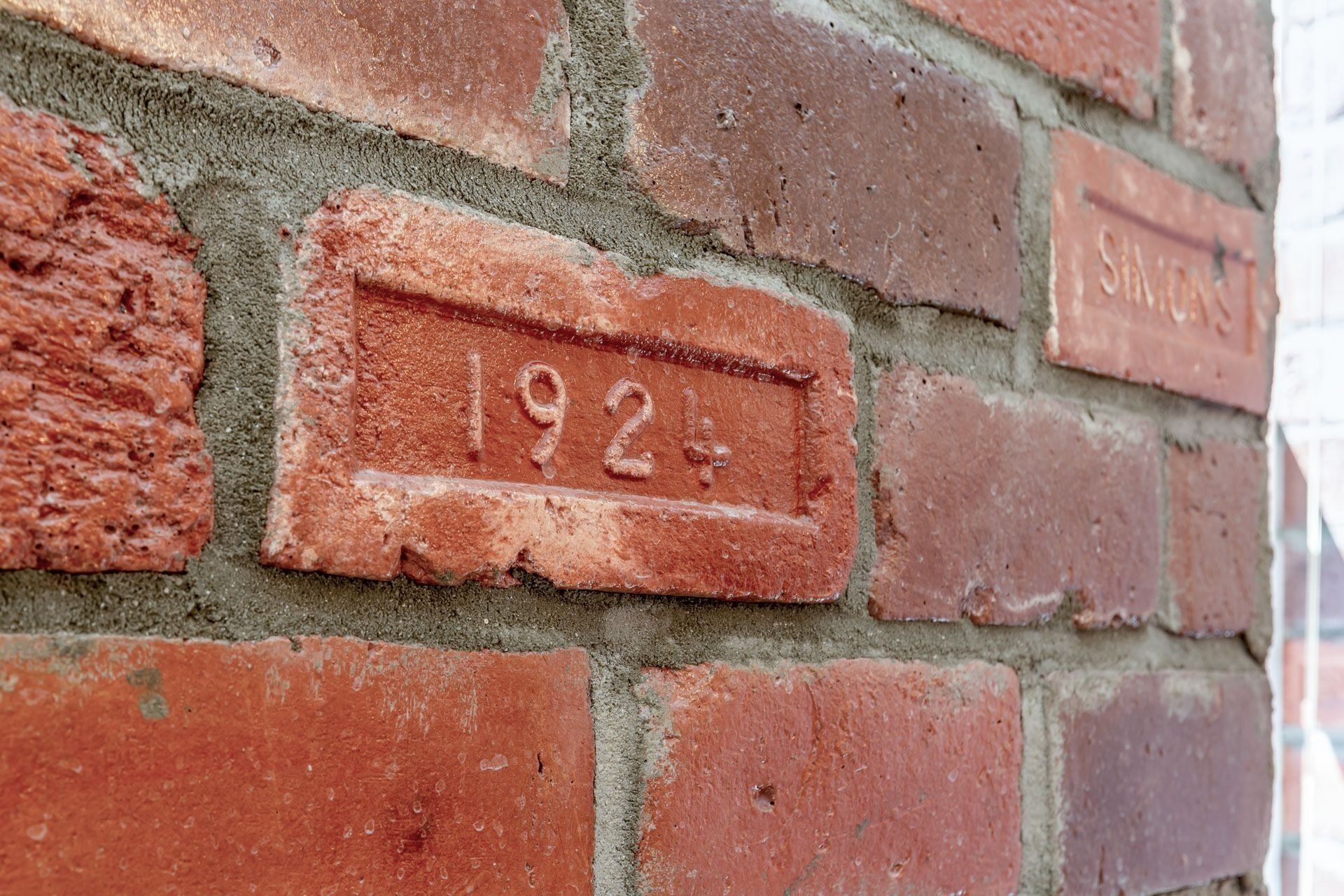 Eine Ziegelwand mit einem Schild, auf dem „1924“ steht.