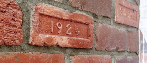 Eine Ziegelwand mit einem Schild, auf dem „1924“ steht.