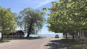 A parking lot with picnic tables and a view of the sea. - Lakeside condo. (Oscoda)