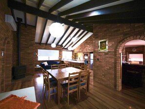 Un interior acogedor con una mesa de comedor de madera, un sofá y una zona de cocina.