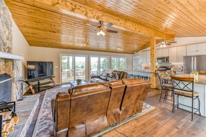 Relax in a comfortable living area with a leather sofa, stone fireplace, and modern entertainment unit.
