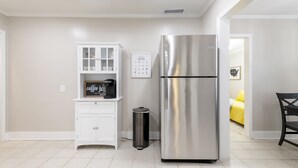 A kitchen with a stainless steel refrigerator, a white cabinet, and a trash can. - Charming entire house only 5 miles from Truist Park. (Smyrna)