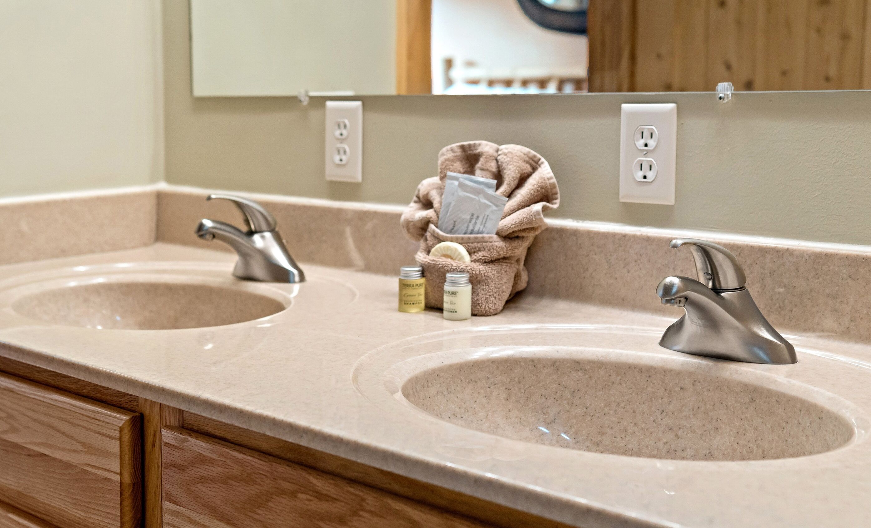 Un bagno con due lavandini, un asciugamano e articoli da toilette.