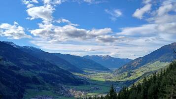 Eine gebirgige Landschaft mit einem Tal, einer Stadt und einem klaren Himmel.