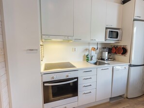 A modern kitchen with white cabinetry, a built-in microwave, a stove, and a dishwasher.