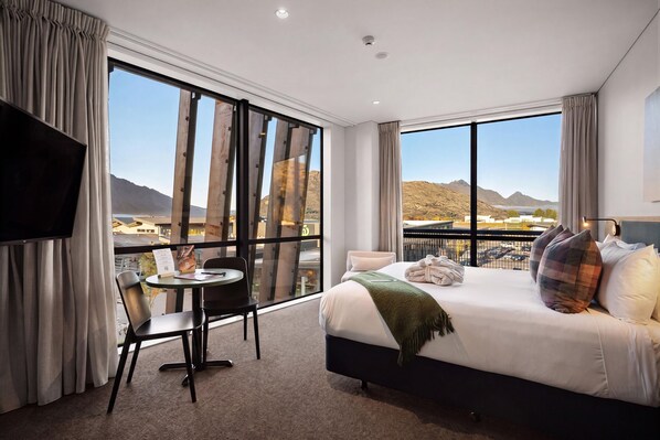 A hotel room with a large bed, a desk, and a TV. - Sudima Queenstown Five Mile (Queenstown)