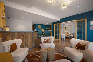 A modern reception area with a wooden reception desk, plush seating, and a blue accent wall.
