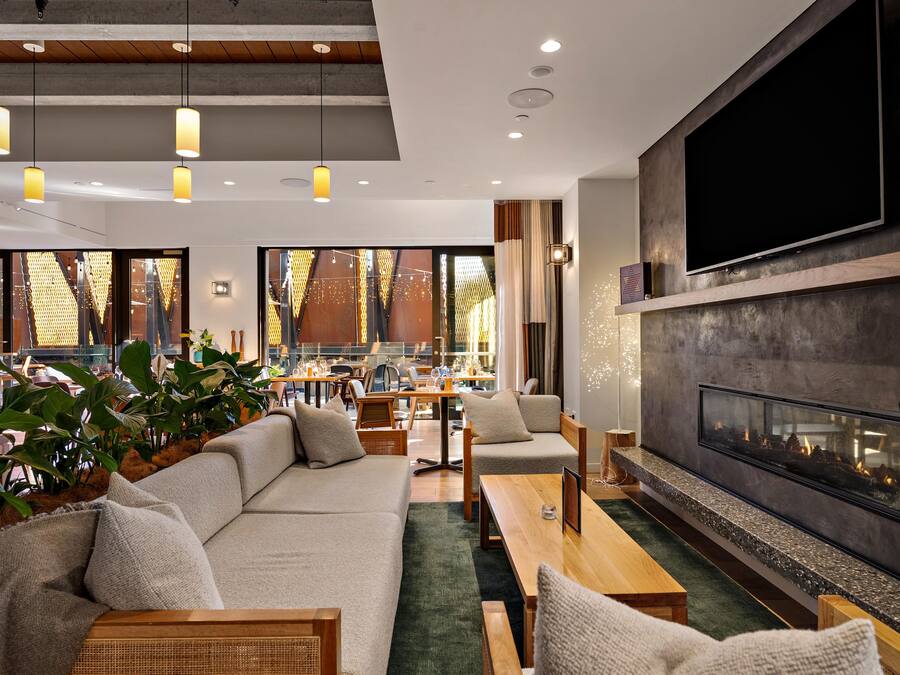 A modern interior with a sofa, chairs, a fireplace, and a dining area.