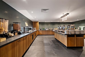 A modern kitchen with wooden cabinets, a central island, and a variety of appliances. - Sudima Queenstown Five Mile (Queenstown)