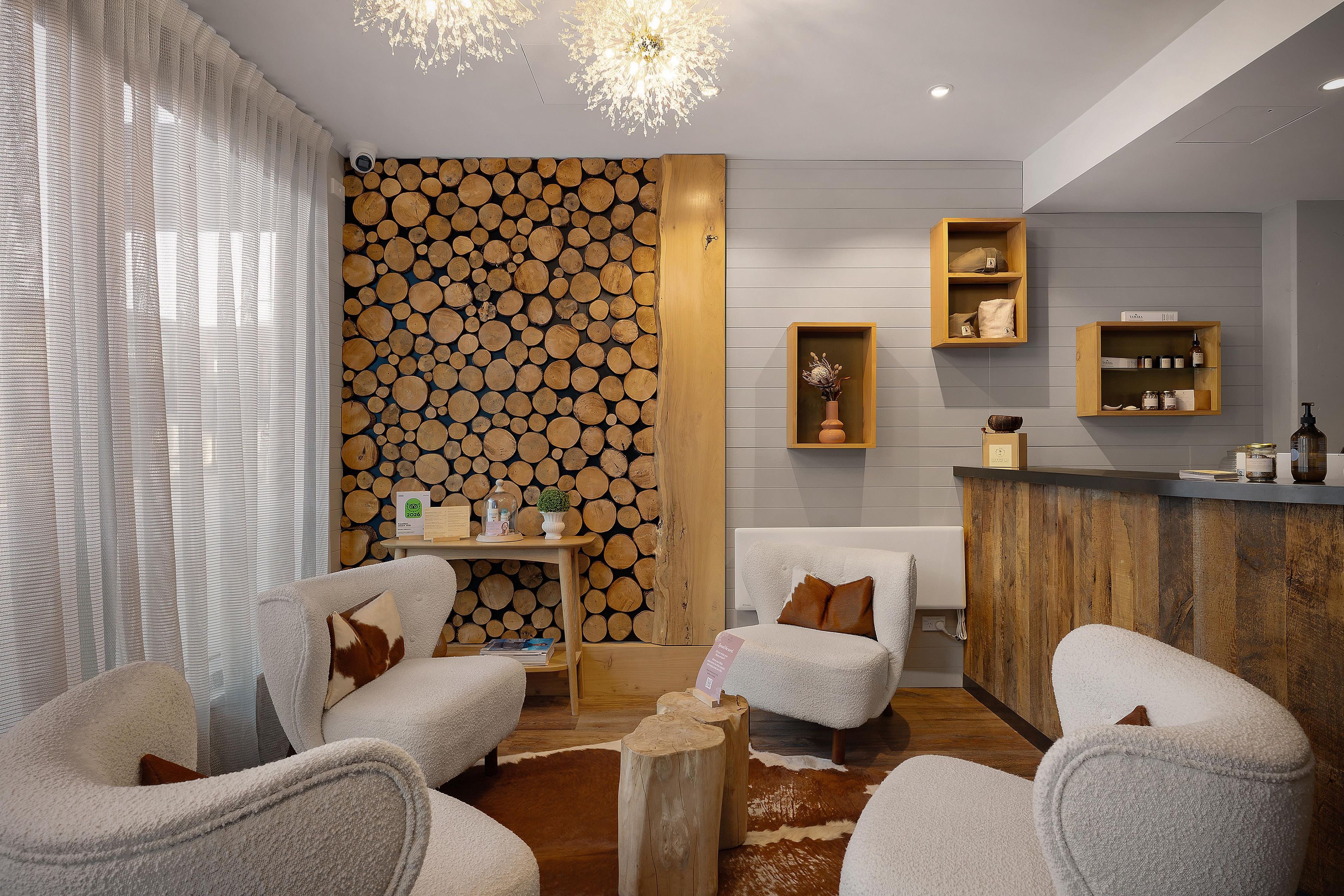 A modern interior with a fireplace, seating area, and wooden wall decor.