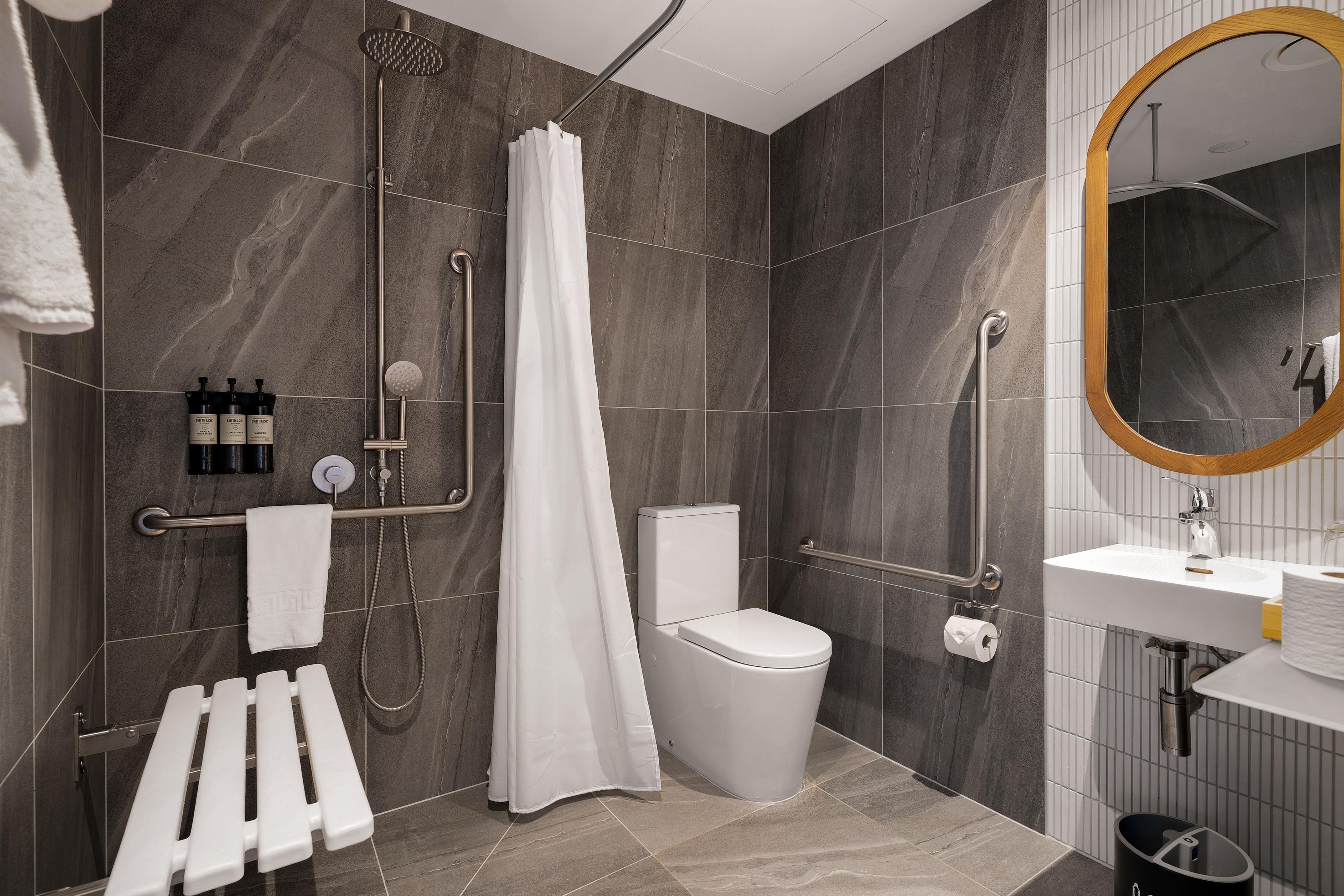 A modern bathroom with a shower, toilet, and sink.