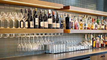 Un espace bar avec des étagères remplies de bouteilles de vin et de verres.