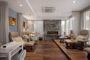 Una sala de estar moderna con chimenea, sofás de cuero y una pared de acento de piedra.