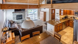 Una cocina moderna con armarios de madera, una isla grande y una chimenea de piedra.