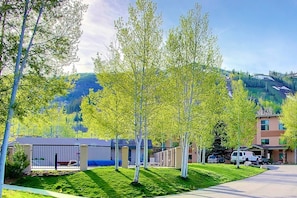 A residential area with a building, a parking lot, and a mountain in the background. - Ski In/Out-Pool-HotTub-Views-Grill-Just Remodeled (Steamboat Springs)