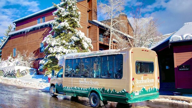 Un autobús estacionado frente a un edificio con un letrero que dice "Steamboat Resorts By Wyndham Vacation Rentals".