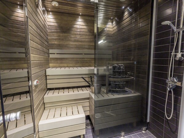 A modern shower area with a glass partition, a bench, and a built-in heater.