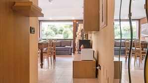 Une cuisine moderne avec des meubles en bois, un four encastré et un coin repas comprenant une table et des chaises.