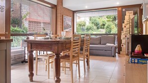 Un coin repas avec une table et des chaises en bois, un canapé et un escalier décoré pour Noël.
