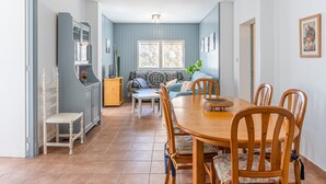 A dining area with a wooden table and chairs, a sofa, and a cabinet. - Holiday Home "Ana House" with Sea View, Wi-Fi & Terrace (CAN PASTILLA)