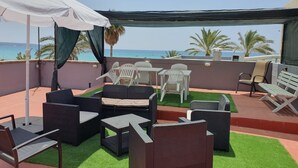 A rooftop terrace with outdoor furniture, a white umbrella, and a view of the sea. - Holiday Home "Ana House" with Sea View, Wi-Fi & Terrace (CAN PASTILLA)