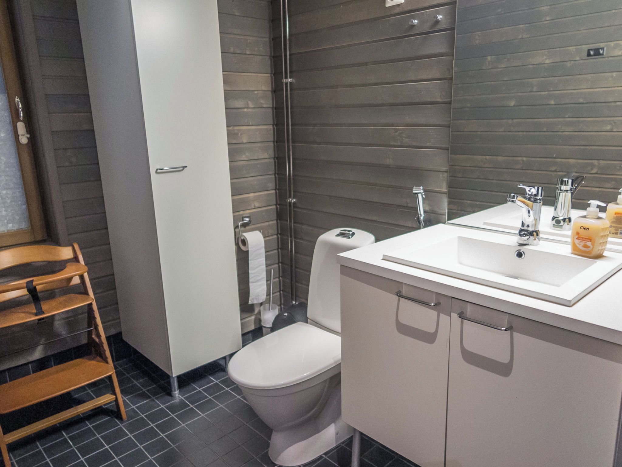A modern bathroom with a toilet, sink, and mirror.