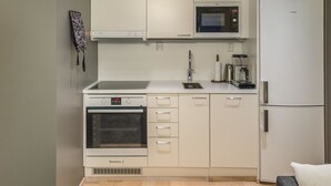A modern kitchen with a built-in oven, microwave, and refrigerator.