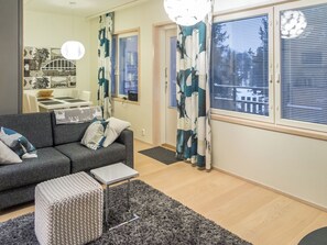 A modern living room with a grey sofa, a small side table, and a grey rug.