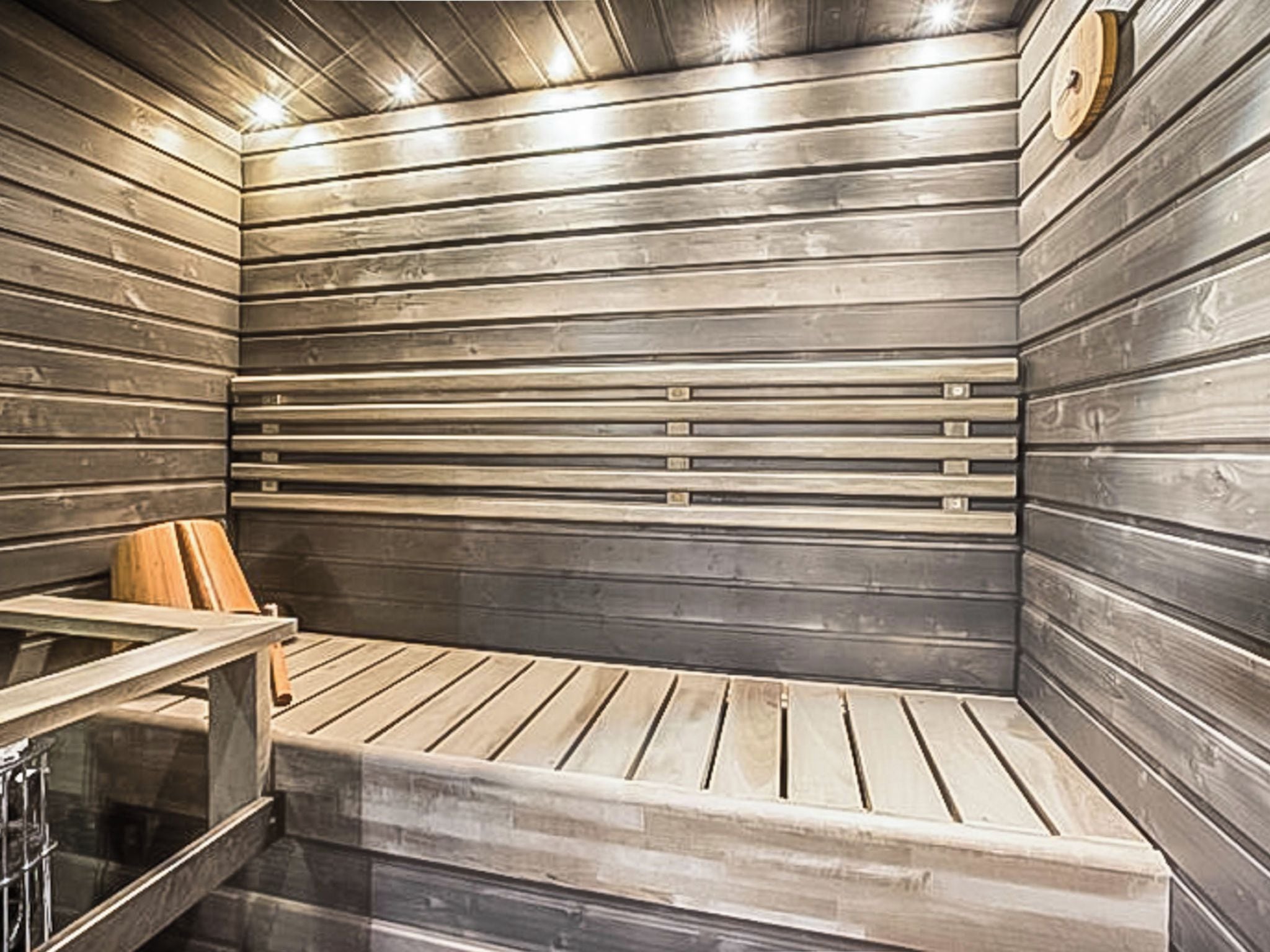 Eine Sauna mit Holzlamellen an den Wänden und einer Sitzbank.