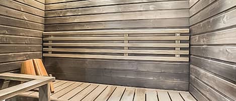 Eine Sauna mit Holzlamellen an den Wänden und einer Sitzbank.
