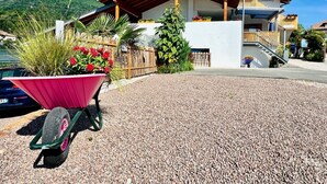 A building with a wooden roof, a gravel driveway, and a mountain backdrop.