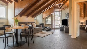 Ein modernes Interieur mit Esstisch, Stühlen, einer Couch und einem Fernseher.