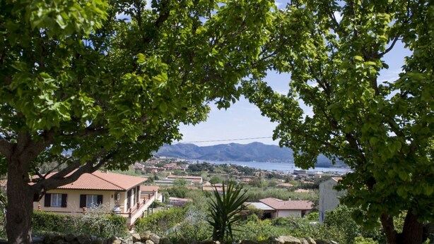 A coastal town with houses, a mountain in the background, and a clear sky. - Silvia Loft on Hill between Green & White Coast (Portoferraio)