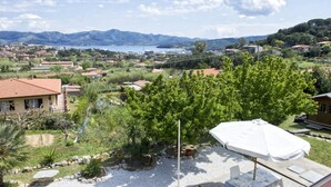 A residential area with houses, a garden, and a view of mountains and a lake. - Silvia Loft on Hill between Green & White Coast (Portoferraio)