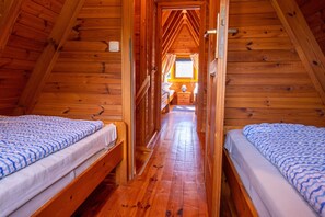 A wooden cabin with two beds, a hallway, and a window with curtains. - Finnish Cabin 2 - Finnish Cabins in Freest (Kröslin)