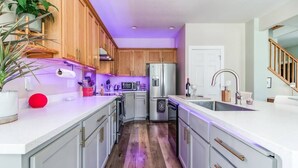 Una cocina moderna con armarios de madera, electrodomésticos de acero inoxidable y encimera blanca.