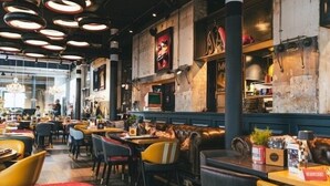 Ein Restaurantinneres mit Sitzecken, Tischen und einer Bar.