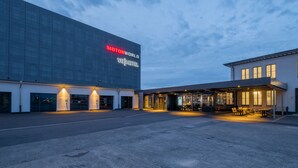 Ein modernes Hotel mit einem großen Schild, auf dem 'MOTORWORLD V8 HOTEL' steht.