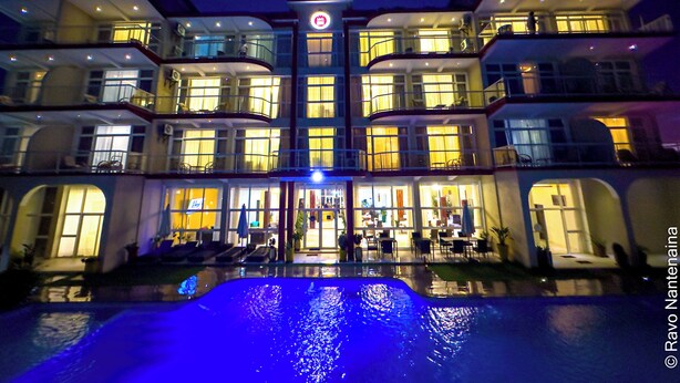 A multi-story hotel with a swimming pool in the foreground. - Menabe'l (Antsirabe)
