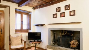 Una sala de estar acogedora con chimenea, muebles de madera y cuadros en la pared.