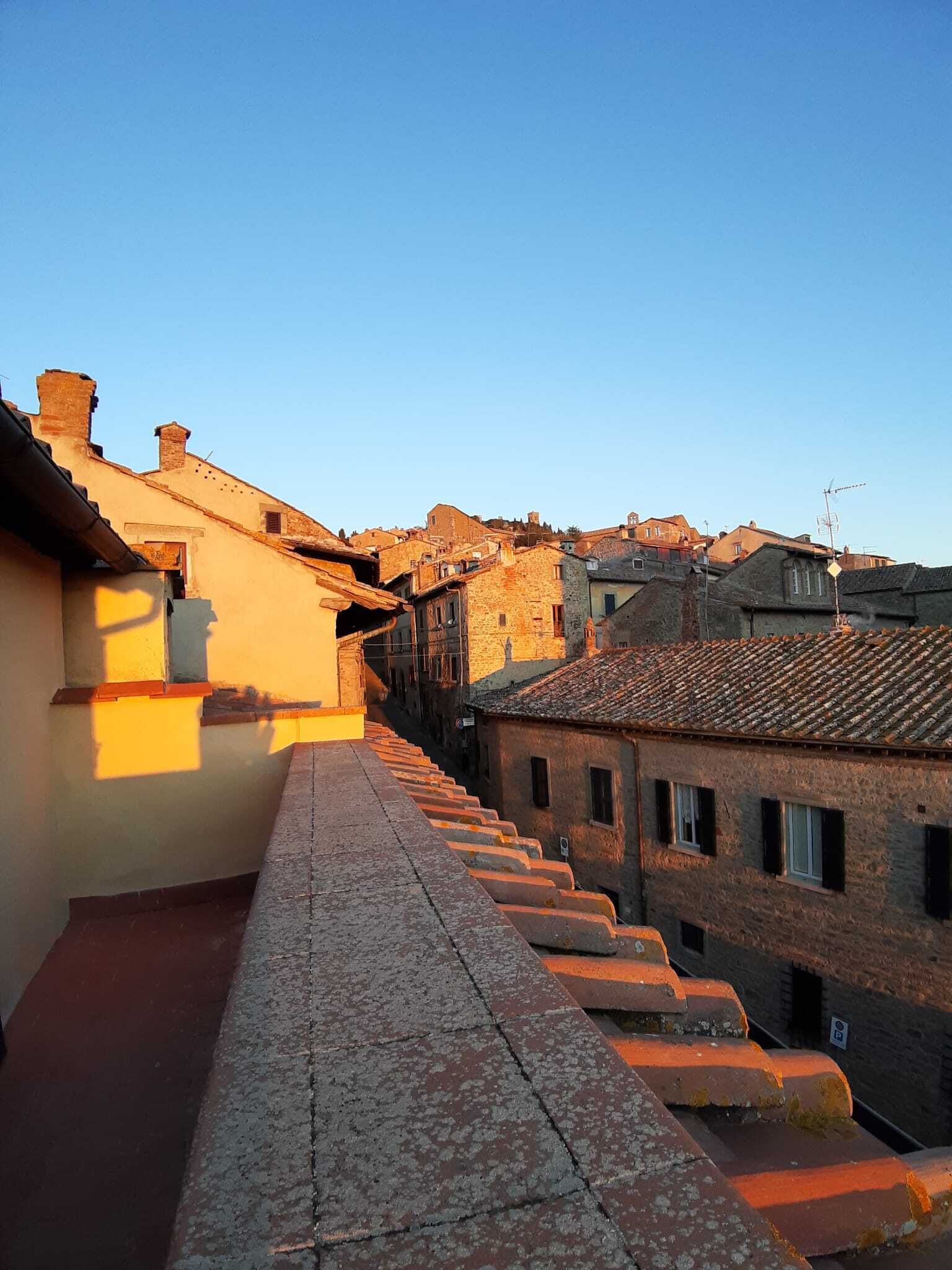 Une rue étroite, bordée d’escaliers en terre cuite qui mènent à des bâtiments traditionnels aux façades en pierre et aux toits couverts de tuiles.