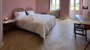 A bedroom with a bed, bedside tables, a desk, and a chair. - A quaint vineyard gîte at Château Magdeleine Bouhou (Cars)
