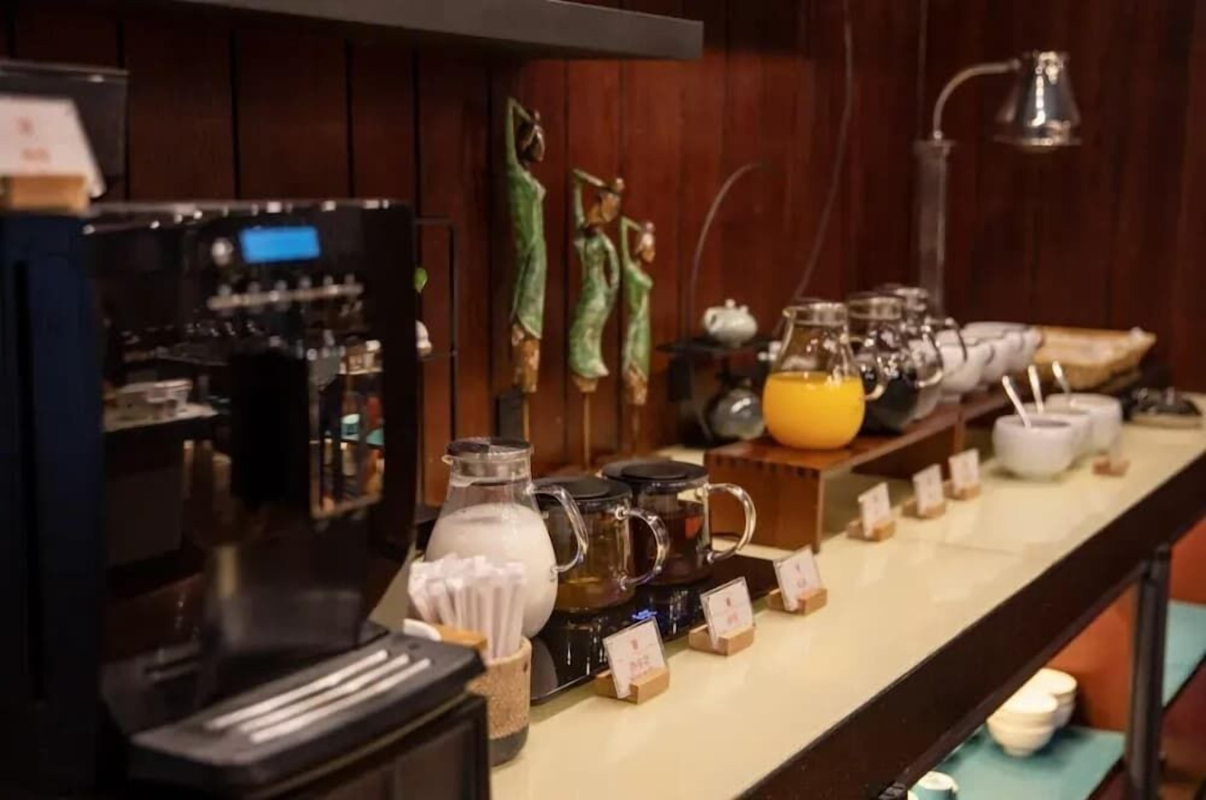 A coffee station with a coffee machine, various mugs, and a kettle.