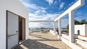 A rooftop terrace with a view of the sea, white walls, and a stone floor. - Villetta Roberta - Primo Piano by BarbarHouse (Santa Maria al Bagno)