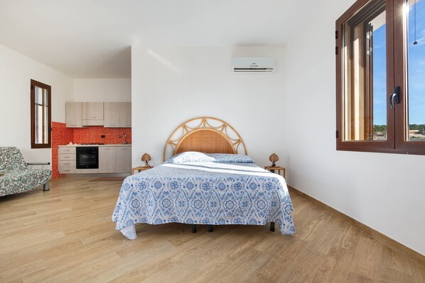 A bedroom with a bed, wooden headboard, bedside tables, and a window.