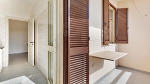 A hallway with a sliding glass door, a wooden door with blinds, and a small shelf. - Carlotta`s House by BarbarHouse (San Foca)