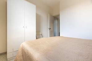 A bedroom with a bed, a wardrobe, and a door leading to another room. - Carlotta`s House by BarbarHouse (San Foca)