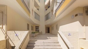 Un edificio de varios niveles con una escalera central que conduce a una puerta en la parte superior.